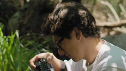 一位年轻的摄影师在相机显示屏上查看照片[免费商用]