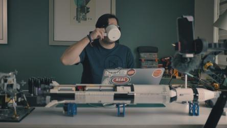 一名男子拿着书房里的笔记本电脑，周围有很多东西[免费商用]