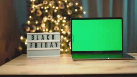 笔记本电脑旁的黑色星期五标志准备购物[]