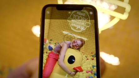 一位年轻的网红骑着一只巨大的橡皮鸭在一个塑料球坑里游泳。[免费商用]