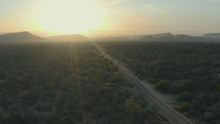 日落时，飞越一条有公路的自然地貌[免费商用]