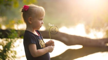 小女孩闻着大自然中的花朵[]