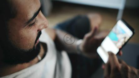 男子在智能手机上浏览社交媒体俯视图[]