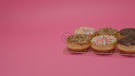 粉红色背景上的六个上釉甜甜圈[免费商用]