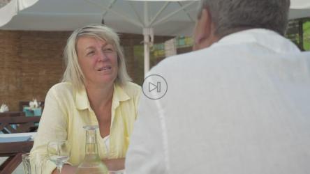 Elderly couple talking over lunch[]