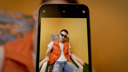 智能手机记录一名年轻男子在沙滩椅上唱歌和摆姿势[免费商用]