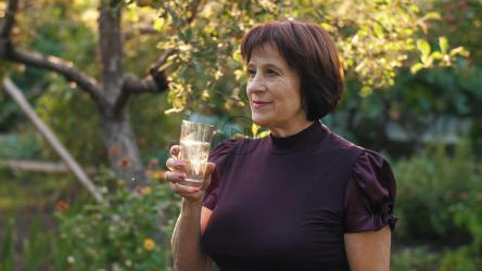 一位老妇人在自家花园里喝水[]