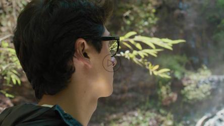 一个年轻人用相机拍摄瀑布的照片[免费商用]