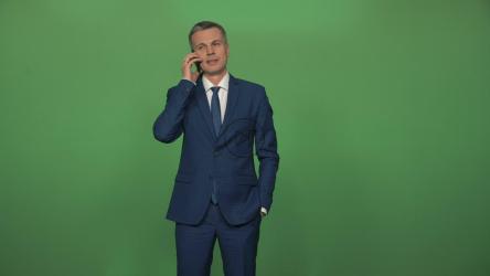 一名身穿西装的男子在绿色屏幕前打电话[4K]