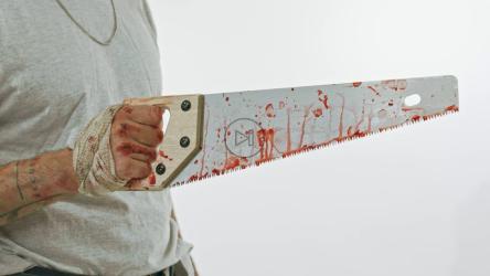 杀人者手持血迹斑斑的锯子[免费商用]