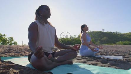 一对情侣在海滩上的沙滩上冥想[免费商用]