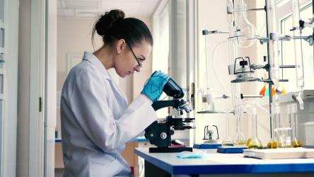 女科学家通过显微镜观察[免费商用]