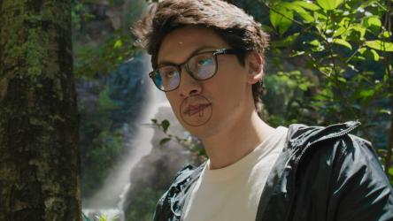 一位戴着眼镜的年轻探险家调整着他的专业相机的焦距[免费商用]