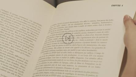 一只手小心翼翼地翻阅着一本艺术书。[免费商用]