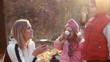 一家人在秋天的森林里喝热饮[]