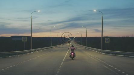 一个孤独的摩托车手晚上在高速公路上开车[]