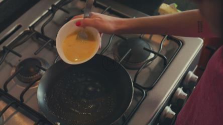 一位妇女早餐在锅里放鸡蛋[4K免费商用]