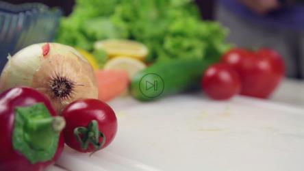 在餐桌上切奶酪和蔬菜的人[]