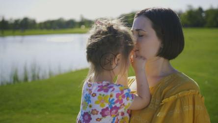 母亲在大自然中亲吻她的小孩[]