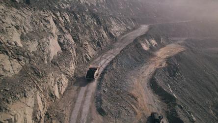 一辆卡车在矿井中沿着长路行驶的鸟瞰图[]
