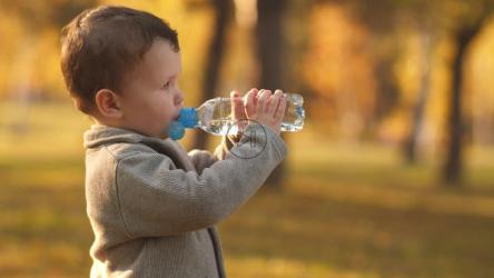 小男孩喝瓶子里的水[]
