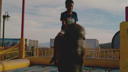 游乐园里骑着机械公牛的男孩[免费商用]