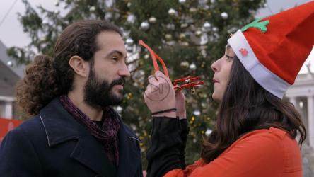 一对情侣在圣诞树前合影亲吻[]