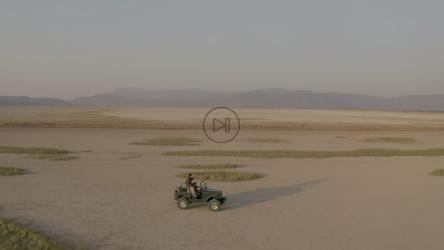 一辆吉普车卡车在沙漠中行驶的航拍照片[免费商用]