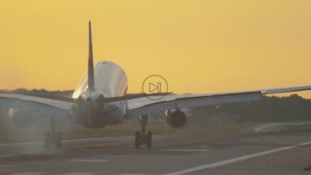 飞机在黄色的天空中以慢动作降落[4K]