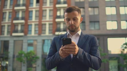 衣冠楚楚的商人用手机发信息[4K免费商用]