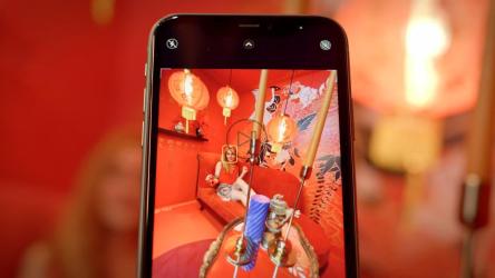 一位年轻女子在东方主题房间的红色沙发上摆姿势[免费商用]