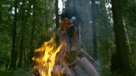 身着审判服的灵媒在火焰上移动双手[]