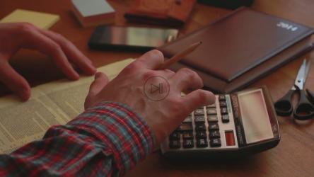 拿着计算器和法律文件的人[]