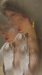 年轻女子在超现实的氛围中跳舞生活方式 Lifestyle:一位涂着醒目红色口红的年轻女子在一种令人着迷和超现实的气氛中跳舞，当她直视镜头时，她迷人的手部动作和梦幻般的表演给观众施了魔法。