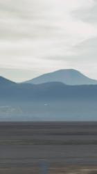 一名戴着头盔的摩托车手快速行驶的特写镜头自行车 Bicycle:一名戴头盔的男子骑着摩托车在阳光明媚的沙漠中央的一条路上快速行驶，在他身边开枪。