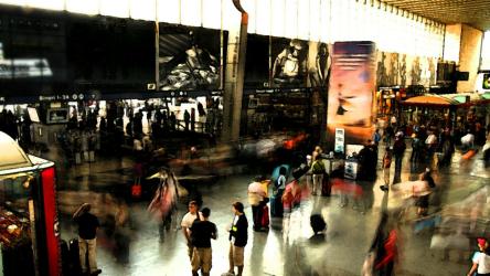 火车站内部火车 Trains:在火车站内部，当人们提着行李箱向四面八方走去时，小售货亭里、行程屏幕上方和一扇大窗户上方都有生意。