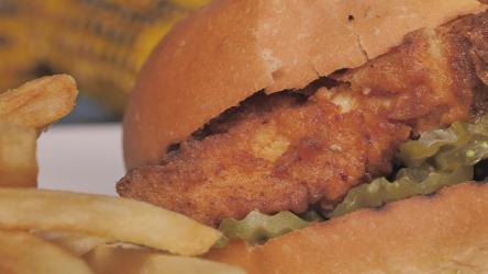 炸薯条鸡肉汉堡快餐 Fast Food:鸡肉汉堡和背景是玉米的炸薯条的细节看起来不太突出。