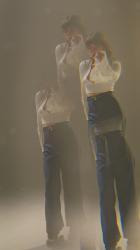 年轻女子在辊叶片上行走和跳舞聚会 Party:一个年轻漂亮女人踩着旱冰走向镜头跳舞的垂直镜头。一位年轻的舞女在梦幻般的环境中踩着旱冰跳舞。