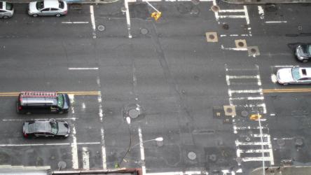 曼哈顿大道交通繁忙出租车 Taxi:一个下午，曼哈顿一条十字路口的航拍照片，当时汽车和人从一边穿过另一边。