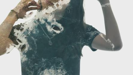 一名女子与海中悬崖的双曝光视频双重曝光 Double Exposure:两次曝光的视频显示，一名女子用手梳头，海岸边的悬崖上，海浪拍打着她的下半身。