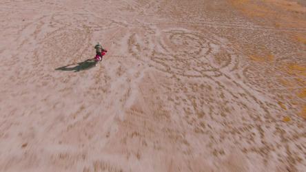 骑摩托车穿越沙漠的男子自行车 Bicycle:从一架移动的无人机上可以看到，一名男子骑着摩托车穿越沙漠进行极限运动。