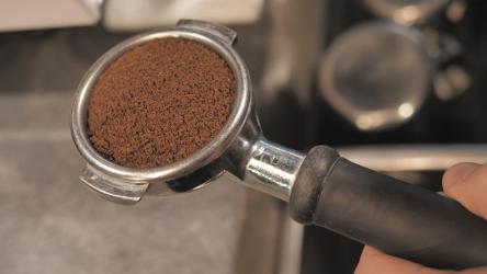为咖啡壶捣碎咖啡咖啡 Coffee:咖啡师为咖啡机准备研磨咖啡。