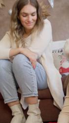 一位坐在沙发上的年轻女子监督着一位戴着圣诞老人帽子的小女孩的创意工作圣诞节 Christmas:一位年轻女子舒适地坐在舒适客厅的毛绒沙发上，热情地监督着一个戴着节日圣诞老人帽的小女孩迷人的创意作品。