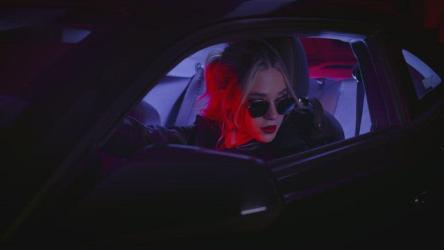 年轻时尚的女人在一辆跑车更多 More:一位年轻时尚的女士戴着墨镜,坐在一辆装有彩色车灯的跑车里,在夜晚的黑暗中。