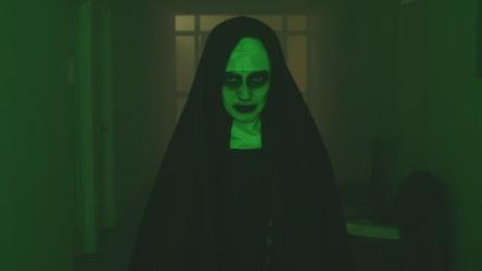 可怕的幽灵修女看着镜头走着更多 More:可怕的鬼修女走在黑暗的走廊上，惊恐地盯着镜头。