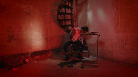 黑暗酷刑室中昏迷的受害者血腥 Gore:黑暗而不祥的是，一名无助的受害者被绑在肮脏的混凝土房间里的螺旋楼梯上。他旁边放着一盘刑具，地上有武器和铁链。