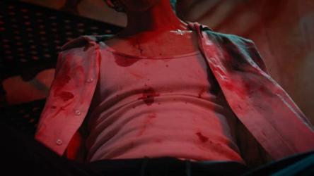 黑暗房间里的血腥酷刑受害者血腥 Gore:卷起一个穿着沾满鲜血的衣服的酷刑受害者的尸体。他们在一个黑暗的房间里，处于近乎昏迷的状态，在这个不祥而血腥的场景中无法移动。