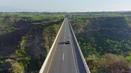 风景如画的公路桥更多 More:一架无人机拍摄了一座公路桥，桥上有汽车经过，桥中央是一片令人惊叹的青山。非常适合自然、旅行或风景内容。